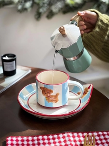 Detail of 3D bear ceramic coffee cup with blue stripes being filled using a moka pot
