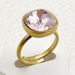 Vue rapprochée d'une bague ouverte dorée ornée d'un zircon rose à coupe carrée