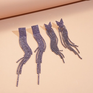 Close-up of elegant purple rhinestone fringe earrings with geometric and butterfly shapes