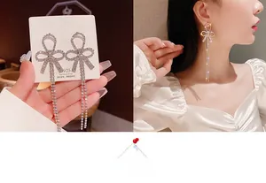 Close-up of S925 silver needle bow earrings with shimmering long tassels and rhinestones