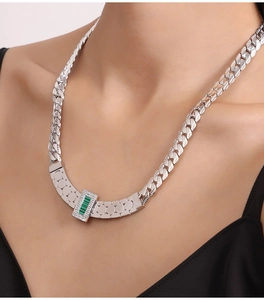 Close-up of silver chain necklace featuring a green striped pendant with sparkling crystals