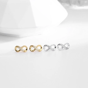 Macro shot of silver and gold infinity stud earrings with sparkling cubic zirconia pavé