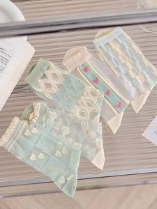 Detail of light blue sheer mesh socks with cute heart patterns and floral embroidery