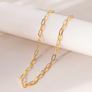 Detailed macro of the 18K gold-plated paperclip chain necklace on a white pedestal