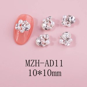 Detail view of 10x10mm silver camellia nail charms with white pearls and sparkling rhinestones