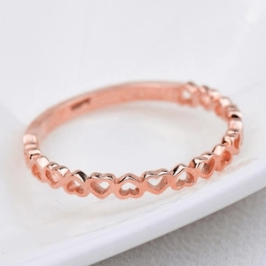 Macro shot of rose gold openwork heart ring with elegant hollow heart patterns