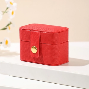 Macro view of compact red PU leather jewelry box with elegant gold metal snap button