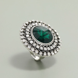 Macro detail of adjustable silver ring with green oval stone and sparkling white crystals