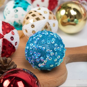 Detail of Christmas foam balls in blue, gold and red arranged on a rustic wooden tray