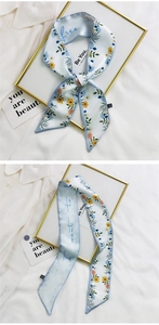 Detail of floral French silk hair ribbon with blue flowers on white shirt backdrop