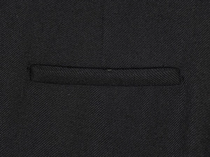 Detailed macro view of high-quality black welt pocket and premium suit fabric texture