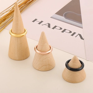 Vista dettagliata di anelli 4mm in oro, oro rosa e nero su supporti in legno naturale