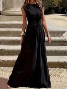 Detail of elegant black sleeveless maxi dress with pleated waist shown on outdoor steps