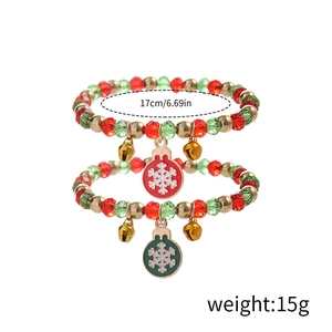 Detail of Christmas beaded bracelet with red green beads and festive snowflake charms