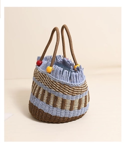 Close-up of striped straw bucket bag with blue fringe tassels and colorful wooden beads