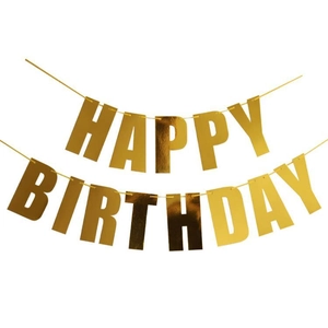 Close-up of shiny gold Happy Birthday letter banner with metallic foil texture