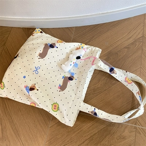Detail of dachshund printed canvas tote bag with a cute plush dog pendant accessory