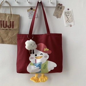 Detail of burgundy duck canvas tote bag featuring cute cartoon print and plush cloud charm