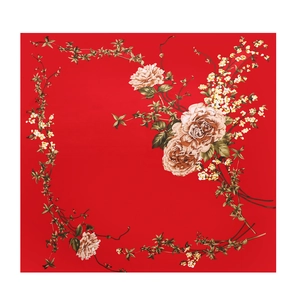 Detailed flat lay of a red silk square scarf with vintage floral and vine patterns