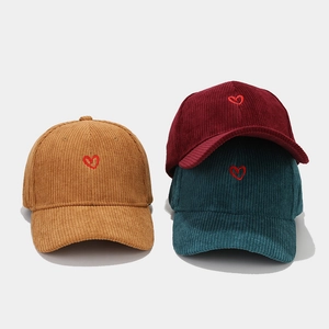 Three corduroy baseball caps in khaki, burgundy, and green with red heart embroidery