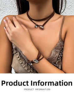 Detail of double-layer brown leather choker and matching bracelet with silver organic charms