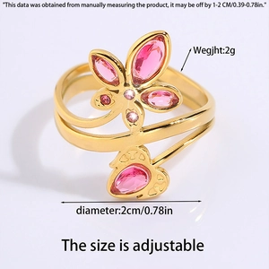 Detailed shot of an adjustable gold steel ring with pink gemstone butterfly and heart motifs