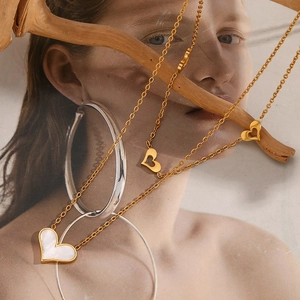 Detail of 18K gold-plated double-layered necklace with white mother of pearl heart pendant