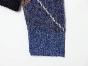 Close-up of knit sweater ribbed cuffs featuring rhombus pattern and fuzzy mohair texture