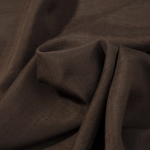 Detailed macro view of dark brown bohemian blouse fabric with fine woven texture