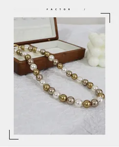 Close-up of tricolor pearls in white, champagne, and bronze on a white textured background