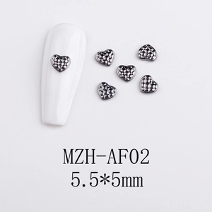 Macro detail of diamond pattern heart nail charms in gunmetal finish with 5.5x5mm size