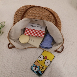 Brown hollow crochet tote bag with beige cotton lining and leather straps for beach vacation