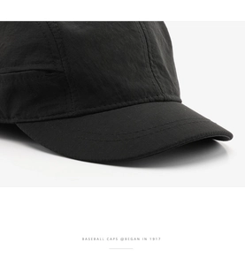 Detailed close-up of a black quick-dry baseball cap with reinforced stitching and micro-texture