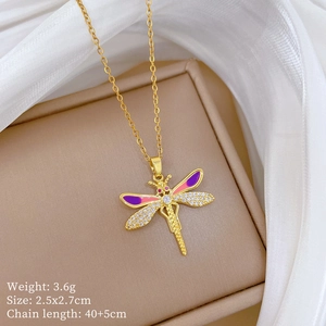 Détail du pendentif libellule dorée avec émail rose et cristaux brillants sur écrin