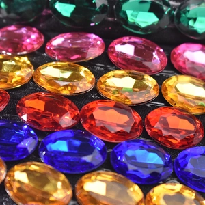 Macro di strass multicolori vivaci con superfici sfaccettate su uno sfondo nero opaco