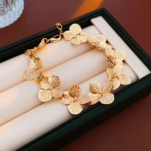 Close-up of golden metal flower chain necklace displayed in a luxury jewelry box