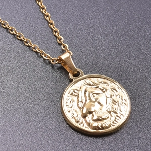 Close-up of gold stainless steel necklace featuring a round lion head relief pendant