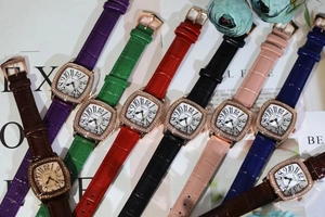 Close-up of square tonneau watch faces with sparkling diamonds and colorful leather straps
