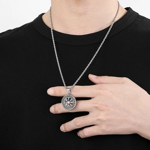 Detail view of silver Viking Vegvisir compass pendant worn over black t-shirt