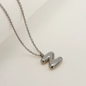Macro view of a 3D bubble capital letter N pendant in polished silver stainless steel