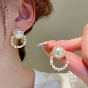 Detail of French vintage pearl earrings with gold metal rim and round dangle ring