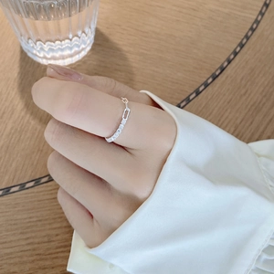 Detail of adjustable S925 sterling silver chain ring with zircons worn on finger