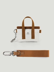 Dettaglio della mini borsa in tela con cinturino marrone e bottone a pressione in metallo