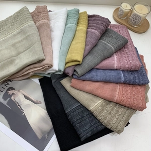 Detailed flat lay of colorful linen cotton scarves featuring delicate lace trim and soft textures