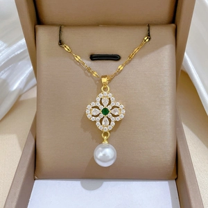 Detail of luxury gold flower necklace with emerald stone and large round white pearl
