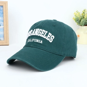 Dark green baseball cap with white Los Angeles embroidery on a wooden background