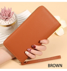 Detailed macro view of the brown lychee pattern leather texture on a long zip wallet