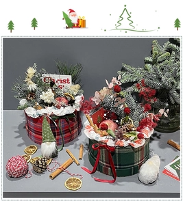 Detail of Christmas gift box set featuring red and green plaid fabric with pine cones and dolls