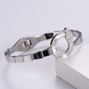 Macro detail of silver snake-scale bracelet with white shell inlay and sparkling crystals