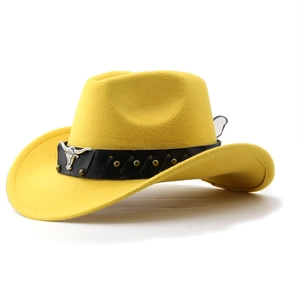 Detail of yellow wool felt cowboy hat with leather band and silver bull head badge